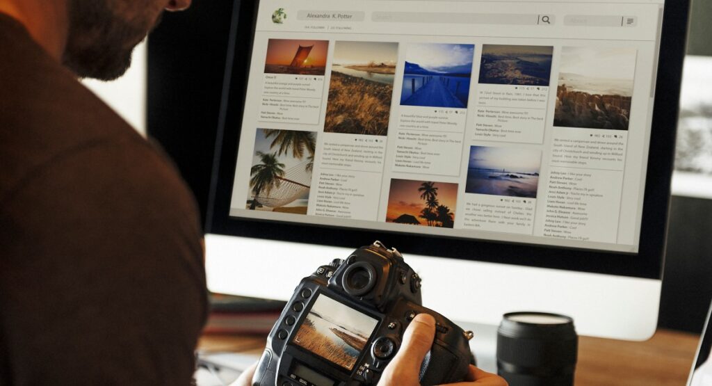 Man contemplating image SEO changes for his website while looking at his camera's viewfinder with a computer with his website in the background